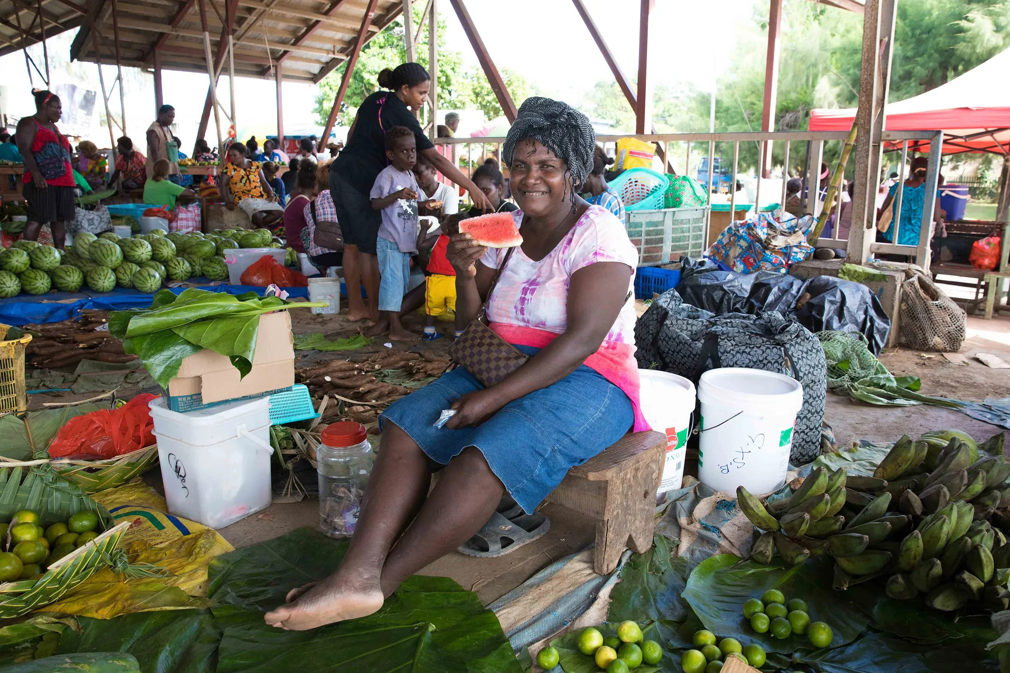 A vendor handing over goods at an open-air market