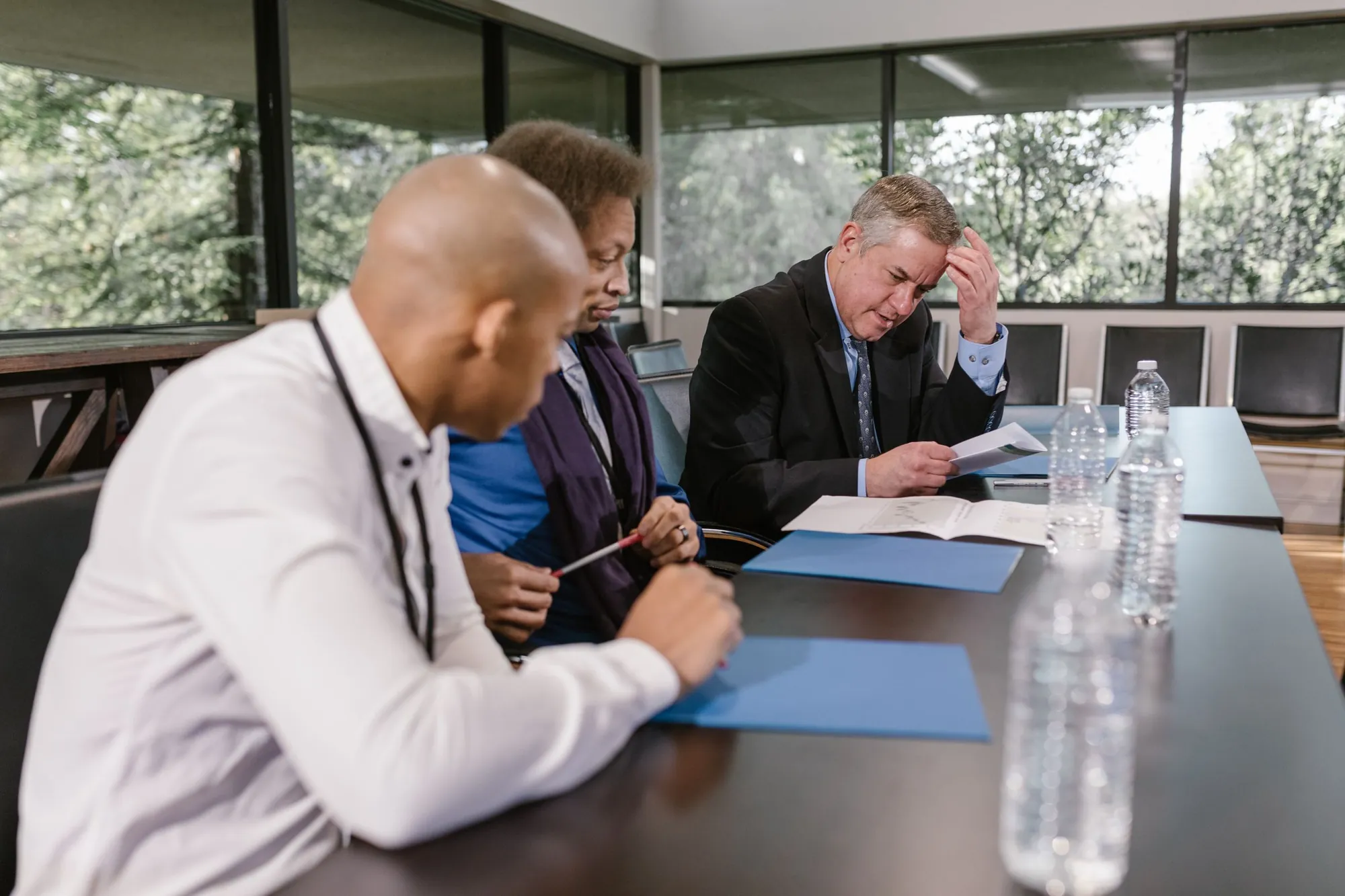 Officials reviewing documents together at a long meeting table