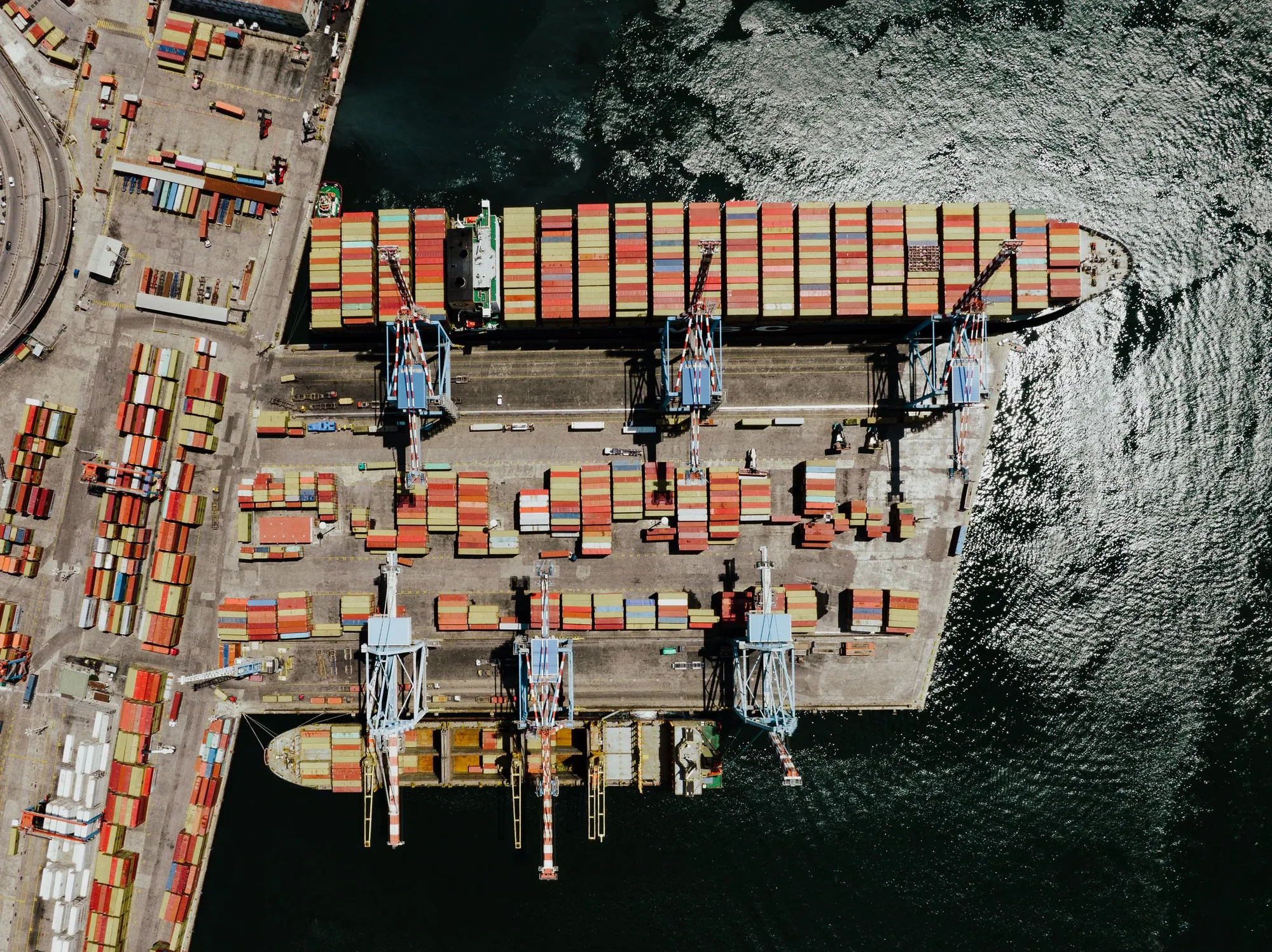 A container ship being loaded at a port, seen from above